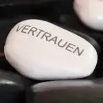weißer Stein mit Beschriftung Vertrauen zwischen schwarzen Steinen als Sinnbild für Vertrauen zwischen Arbeitgeber und Arbeitnehmer sorgt für Mitarbeiterbindung (c) Pixel2013
