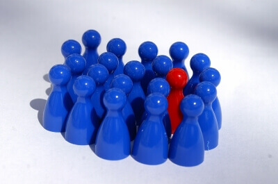 Spielfiguren eine rote und viele blaue (c) Stephanie Hofschlaeger / pixelio.de