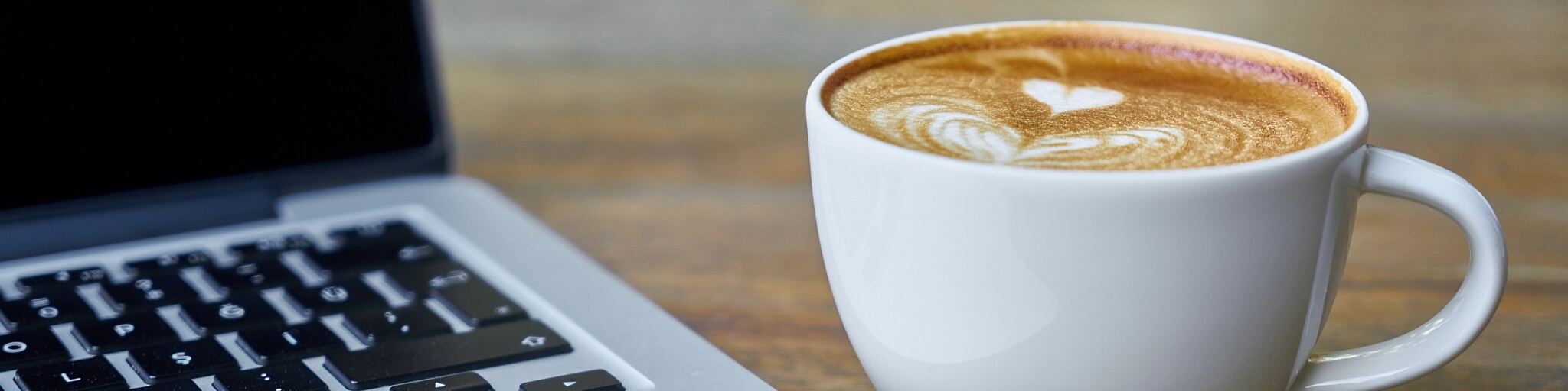 Tasse mit Kaffee und Laptop beim BindungsJourFix in Passau und Leipzig